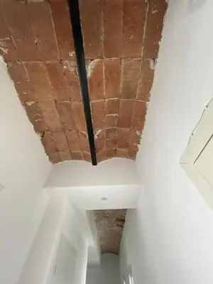 a ceiling in a room with exposed brick at Apartamento Kemacu in Barcelona