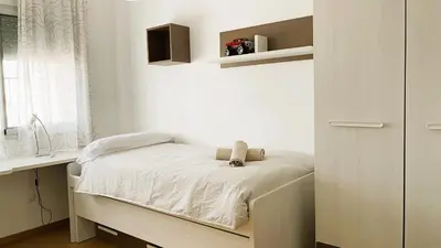 a small bedroom with a bed and a desk at Onze - primera línea de mar con piscina in Cubelles