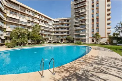 a swimming pool in front of a large apartment building at Apartment Muralla in Vilassar de Mar