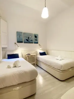 two beds in a room with two tables at Stay U-nique Apartments Gaudi II in Barcelona