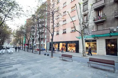 a city street with benches and buildings and people walking at Stay U-nique Apartments Gaudi II in Barcelona
