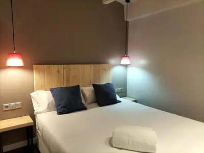 a bedroom with a large bed with two blue pillows at Montserrat Apartments by gaiarooms in Barcelona