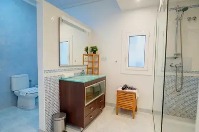 a bathroom with a shower and a sink and a toilet at San Sebastian Apartment by Hello Homes Sitges in Sitges