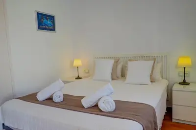 a bedroom with a bed with towels on it at San Sebastian Apartment by Hello Homes Sitges in Sitges