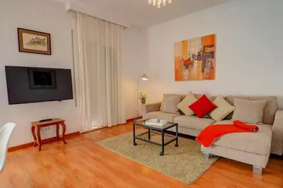 a living room with a couch and a table at San Sebastian Apartment by Hello Homes Sitges in Sitges