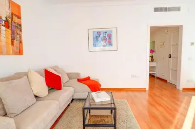 a living room with a couch and a table at San Sebastian Apartment by Hello Homes Sitges in Sitges