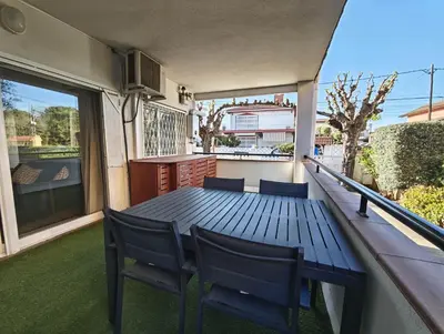 a porch with a wooden table and chairs on a balcony at Apartamento 2 habitaciones y magnífica terraza in Castelldefels
