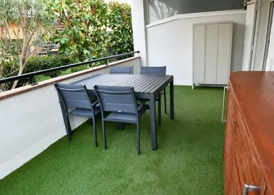 a table and chairs on a balcony with green grass at Apartamento 2 habitaciones y magnífica terraza in Castelldefels
