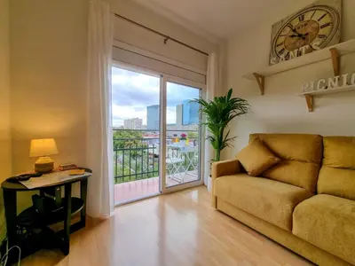 a living room with a couch and a clock on the wall at Apartment PICNIC SANTS in Barcelona
