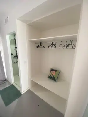 a room with white walls and shelves with a mirror at HUG HOTEL2022 in El Carrer del Canonge
