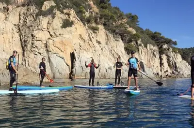 a group of people on paddle boards in the water at RCE Apartments Calella, brand new next to the beach. in Calella
