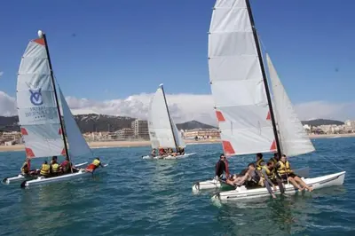 a group of people on small sailboats in the water at RCE Apartments Calella, brand new next to the beach. in Calella
