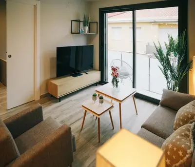 a living room with two couches and a flat screen tv at RCE Apartments Calella, brand new next to the beach. in Calella