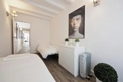a bedroom with a white bed and a white dresser at The White Flats Sant Antoni in Barcelona
