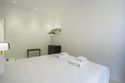 a bedroom with a white bed with towels on it at The White Flats Sant Antoni in Barcelona