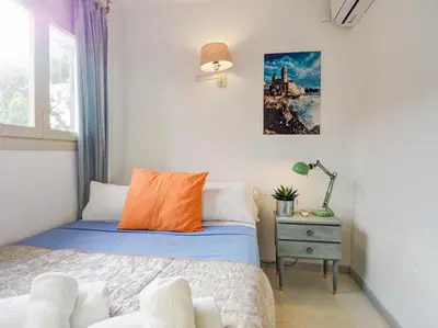 a small bedroom with a bed and a lamp at Ocean Spirit House by Hello Homes Sitges in Sitges