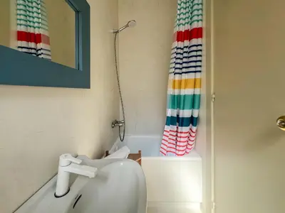 a bathroom with a sink and a shower curtain at Ocean Spirit House by Hello Homes Sitges in Sitges