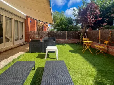 a yard with two benches and a table on grass at Ocean Spirit House by Hello Homes Sitges in Sitges
