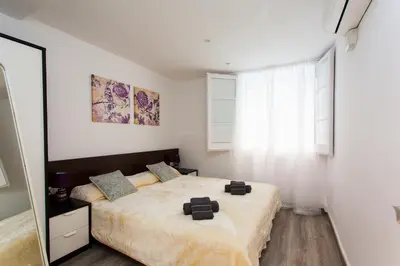 a bedroom with a bed and a large window at Key Gracia Apartments in Barcelona