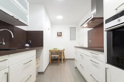 a large kitchen with white cabinets and a sink at Key Gracia Apartments in Barcelona
