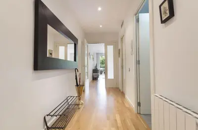 a hallway with white walls and wooden floors at Key Gracia Apartments in Barcelona