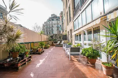 a patio with benches and potted plants on a building at 360 Hostel Borne in Barcelona