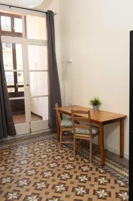 a wooden table and chair in a room with a window at 360 Hostel Borne in Barcelona
