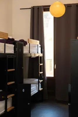 a room with bunk beds with a window and a lamp at 360 Hostel Borne in Barcelona