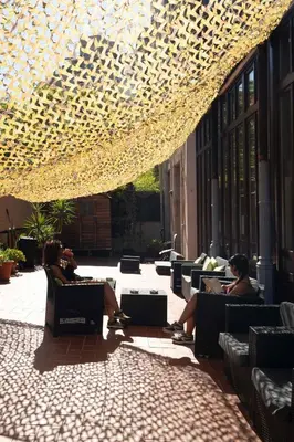 a group of people sitting in chairs under a ceiling with lights at 360 Hostel Borne in Barcelona