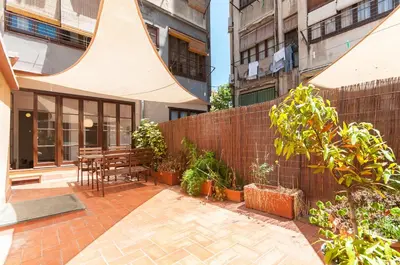 a patio with a wooden table and a fence at Weflating Sant Antoni Market in Barcelona