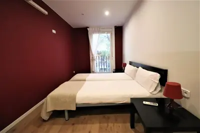 a bedroom with a large bed and a red wall at Weflating Sant Antoni Market in Barcelona