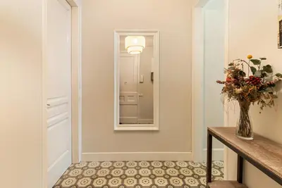 a hallway with a vase of flowers and a mirror at Weflating Sant Antoni Market in Barcelona
