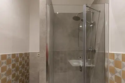 a shower with a glass door and a sink at Weflating Sant Antoni Market in Barcelona