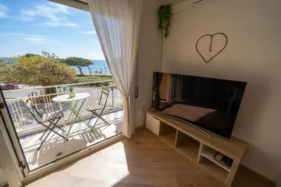 a living room with a large flat screen tv and a balcony at HomeHolidaysRentals Eiffel - Costa Barcelona in Pineda de Mar