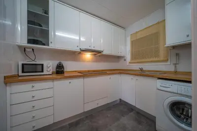 a kitchen with white cabinets and a microwave at HomeHolidaysRentals Eiffel - Costa Barcelona in Pineda de Mar
