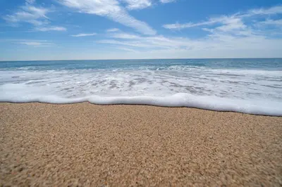 a sandy beach with the ocean and the waves at HomeHolidaysRentals Eiffel - Costa Barcelona in Pineda de Mar