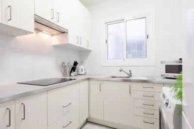 a white kitchen with white cabinets and a window at Sagrada Familia LEPANT in Barcelona