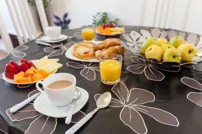 a table topped with plates of fruit and a cup of coffee at Sagrada Familia LEPANT in Barcelona