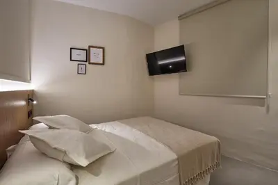 a bedroom with a bed with a television on the wall at Ella Hostel Ramblas in Barcelona
