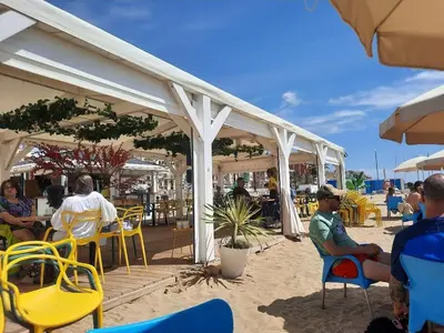 a group of people sitting in chairs on the beach at Bright with pool near the beach and Barcelona by train in Masnou