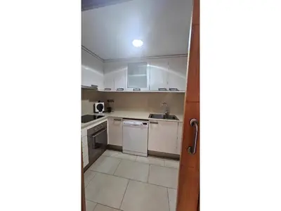 a kitchen with white cabinets and a sink at Apartament Calella in Calella