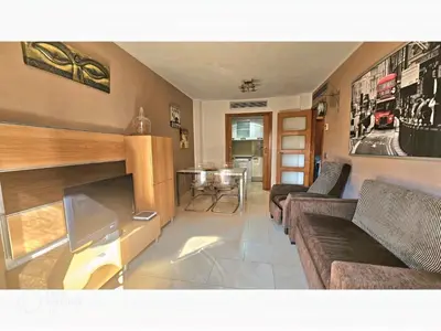 a living room with a couch and a tv at Apartament Calella in Calella