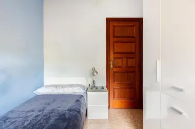 a bedroom with a bed next to a door at Cal Kim in Martorell