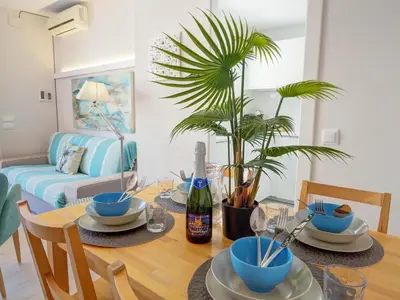 a dining room with a table and a palm tree at Carreta Sea Views by Hello Homes Sitges in Sitges