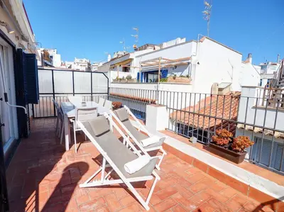 a balcony with white chairs and a table on a building at Carreta Sea Views by Hello Homes Sitges in Sitges