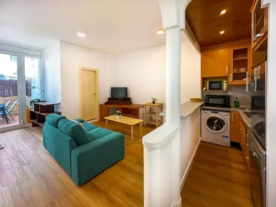 a kitchen with wooden cabinets and a counter top at La Cubana Apartment by Hello Homes Sitges in Sitges