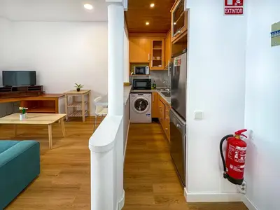 a living room with a green couch and a table at La Cubana Apartment by Hello Homes Sitges in Sitges