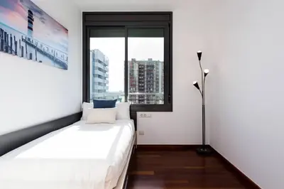 a bedroom with a bed and a large window at Modern Luxury Apartment Fira Bcn in Hospitalet de Llobregat