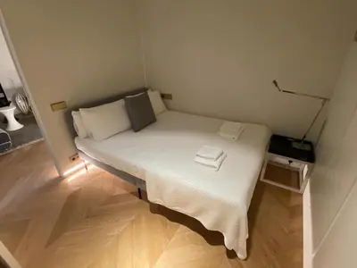 a small bed in a small room with a wooden floor at Luxury Paseo de Gracia Casa Batlló in Barcelona