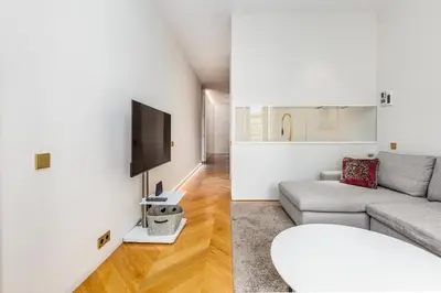 a living room with a couch and a tv on a wall at Luxury Paseo de Gracia Casa Batlló in Barcelona